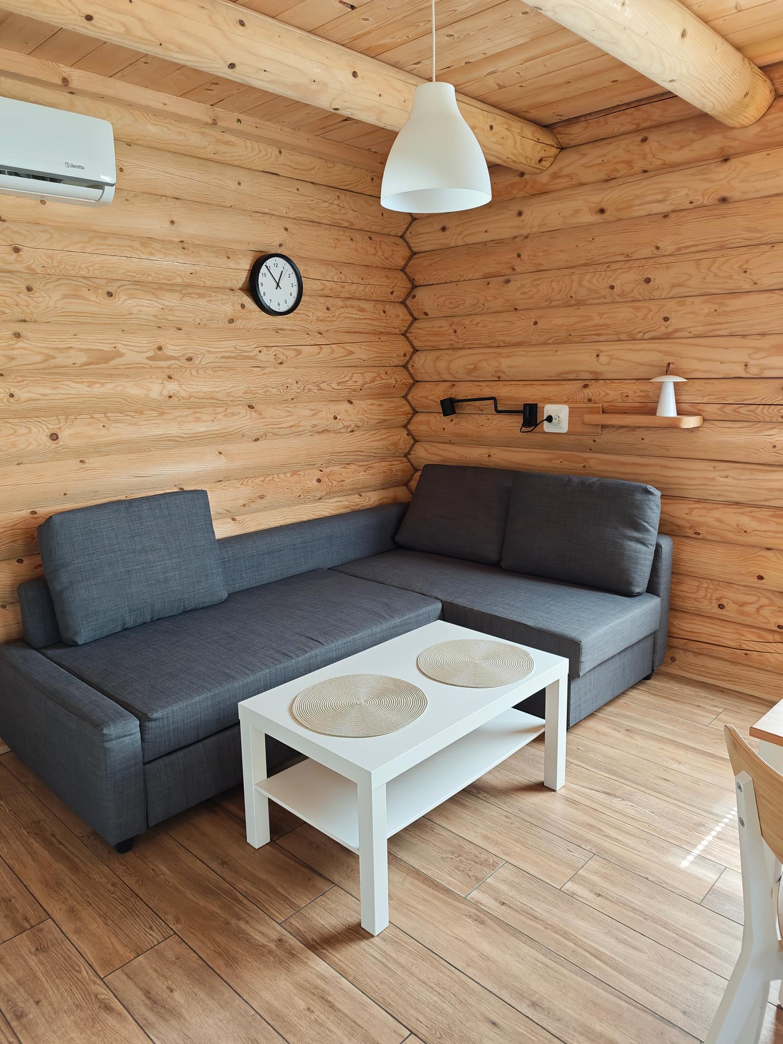 Salon z rozkładaną sofą narożną i stolikiem